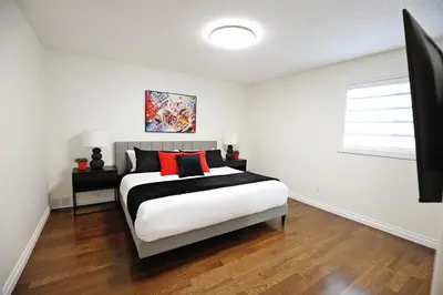 a bedroom with a bed with red and black pillows at Family Pet Friendly AC Disney Near WEM in Edmonton