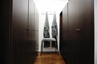 a hallway with brown cabinets and a chair in a room at Family Pet Friendly AC Disney Near WEM in Edmonton