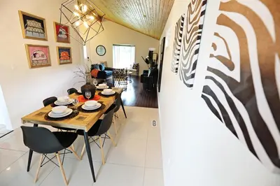 a dining room and living room with a table and chairs at Family Pet Friendly AC Disney Near WEM in Edmonton