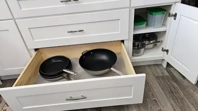 a kitchen with two pots and pans in a drawer at Luxury Basement Suite with 2 Bedrooms, 2 Queen Beds, Free Wi-Fi, and Free Parking in Calgary