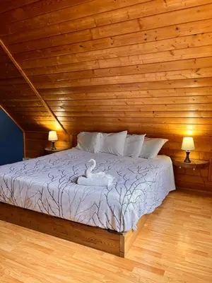 a bedroom with a bed with a wooden wall at Bear Cove Cottages in Port Hardy