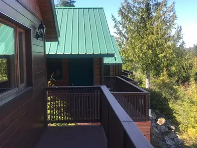 a porch of a house with a green roof at Bear Cove Cottages in Port Hardy