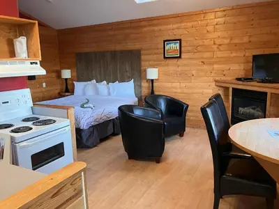 a hotel room with a bed and a table and chairs at Bear Cove Cottages in Port Hardy