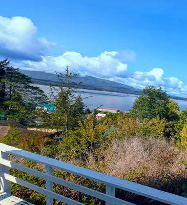 a view of a body of water with a white fence at Cliff Haven on the Bay in Alert Bay