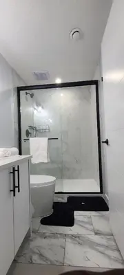 a bathroom with a shower and a white toilet at Amy's 2-Bedroom Residence in Calgary