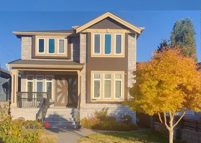 a house with a tree in front of it at Near Skytrain Metrotown Private Entry 3min walk to grocery food in Burnaby