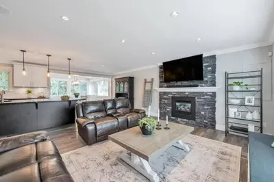 a living room with leather furniture and a fireplace at Cozy home in Brookswood in Langley