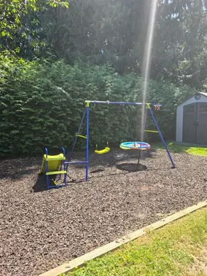 a playground with two swings in a yard at Cozy home in Brookswood in Langley