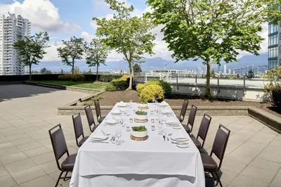 a long table with a white table cloth and chairs at Element by Westin Vancouver Metrotown in Burnaby