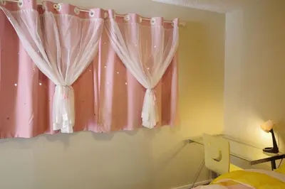 a bedroom with a window with pink curtains at Capilano Happylife in North Vancouver