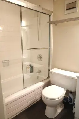 a white bathroom with a toilet and a shower at Capilano Happylife in North Vancouver