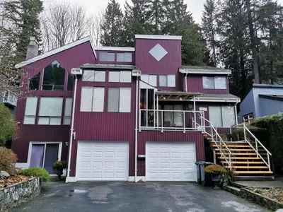 a red house with two garage doors at Capilano Happylife in North Vancouver
