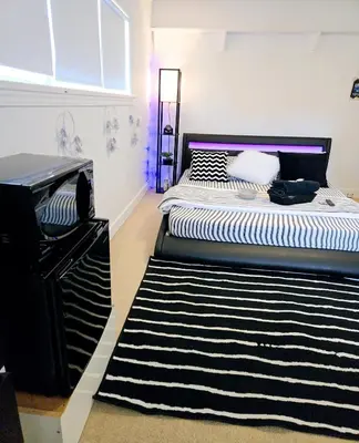 a bedroom with two beds and a rug at Comfy Stylish Room in the Heart of Vancouver- Private Parking, Self Check-in & just 4 mins to Metrotown! in Vancouver