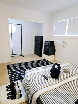 a bedroom with two beds and a television at Comfy Stylish Room in the Heart of Vancouver- Private Parking, Self Check-in & just 4 mins to Metrotown! in Vancouver