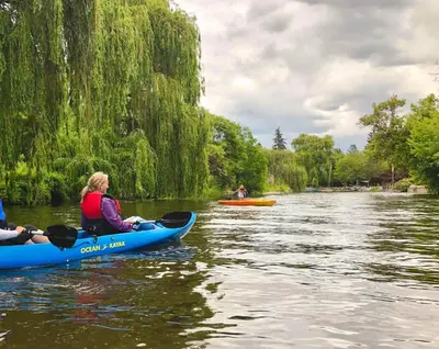two people in kayaks on the water on a river at Kelowfornia Lakeview Retreat in Kelowna