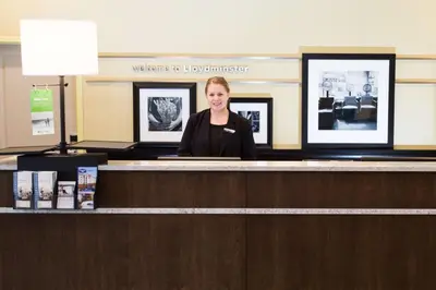 a woman sitting at a counter in a room at Hampton Inn by Hilton Lloydminster in Lloydminster