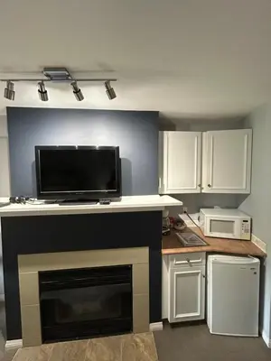 a kitchen with a counter with a tv and a microwave at Borgata Lodge Resort in Kelowna