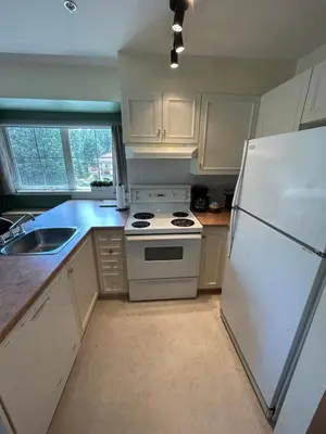 a kitchen with white appliances and a white refrigerator at Borgata Lodge Resort in Kelowna