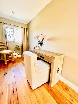 a living room with a table with a vase of flowers at Oceanside Manor - Fancy Room - Golf course & Beach View in Qualicum Beach