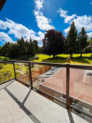 a balcony with a view of a park at Oceanside Manor - Fancy Room - Golf course & Beach View in Qualicum Beach