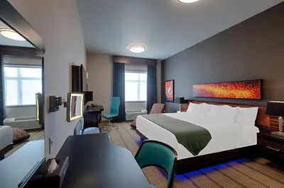 a hotel room with a bed and a desk and chairs at Hotel Clique Calgary Airport in Calgary