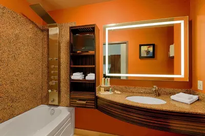 a bathroom with a tub and a sink and a mirror at Hotel Clique Calgary Airport in Calgary