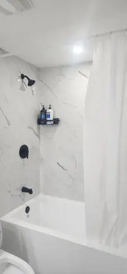 a white bathroom with a tub and a toilet at fabulous and cozy guest suite in Calgary