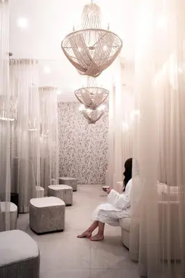a woman sitting on a toilet in a room with curtains at Naturally Pacific Resort in Campbell River