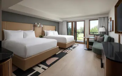 a hotel room with two beds and a couch at Naturally Pacific Resort in Campbell River
