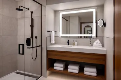 a bathroom with a sink and a mirror and a shower at Naturally Pacific Resort in Campbell River