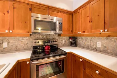 a kitchen with a stove and a microwave at #24 Treeline in Whistler