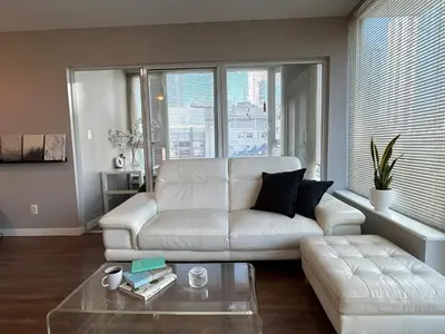 a living room with a white couch and a coffee table at Modern spacious Apt plus Solarium and Den in Downtown Vancouver with Parking and Pool in Vancouver