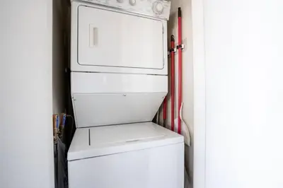 a white refrigerator freezer sitting next to a door at Modern spacious Apt plus Solarium and Den in Downtown Vancouver with Parking and Pool in Vancouver