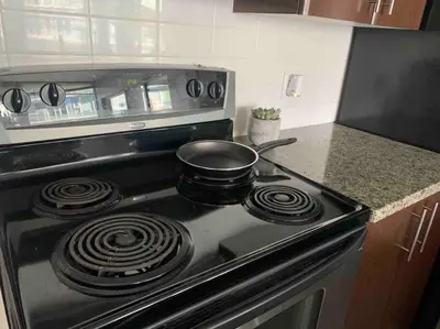 a kitchen stove with a frying pan on top of it at Modern spacious Apt plus Solarium and Den in Downtown Vancouver with Parking and Pool in Vancouver