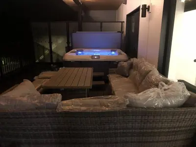 a room with a couch and a table and a hot tub at Base Camp Revy! in Revelstoke