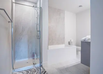 a bathroom with a shower with a glass door at Base Camp Revy! in Revelstoke