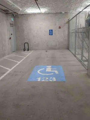 an empty parking garage with a blue sign on the floor at Base Camp Revy! in Revelstoke