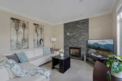 a living room with a couch and a fireplace at Luxurious Multi-Family Home in Vancouver West, 10 Mins Downtown in Vancouver