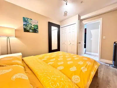 a bedroom with a bed with a yellow comforter at Cozy 1bedroom Suite in Vancouver Westside in Vancouver