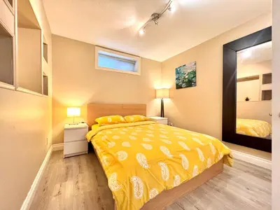 a bedroom with a yellow bed and a mirror at Cozy 1bedroom Suite in Vancouver Westside in Vancouver