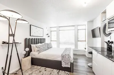 a bedroom with a bed in a white room at Cascade Lodge Premium Suite, with Pool & Hot Tub in Whistler