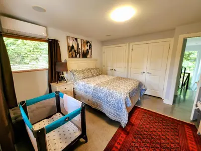a bedroom with a bed and a crib in it at 2BD Guest Suite Sleeps 6 Near Downtown & Beach in West Vancouver