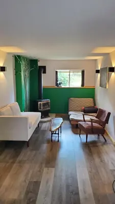 a living room with a white couch and a green wall at Haven Touchstone in Roberts Creek