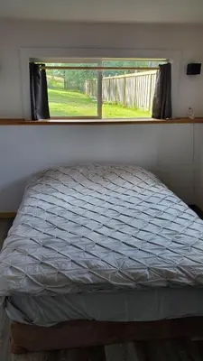 a bed in a room with a window at Haven Touchstone in Roberts Creek