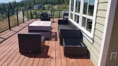 a deck with tables and chairs on a house at La Casa Lakeside Resort - Amazing Panoramic View Lakeside House with Pools, Hot Tubs & More! in Kelowna