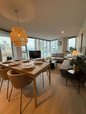 a living room with a table with chairs and a couch at The Altitude with Mountain & City Views, Pool & Hot Tub in Vancouver