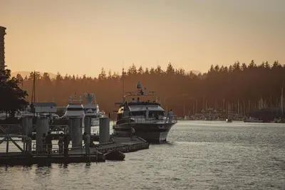 a boat is docked at a dock in the water at The Altitude with Mountain & City Views, Pool & Hot Tub in Vancouver