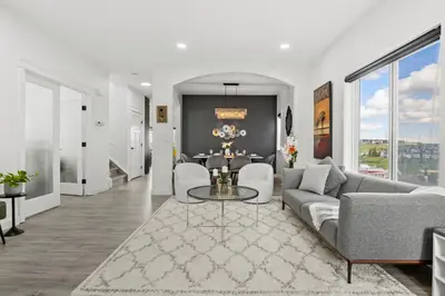 a living room with a couch and a table at LUXURY LAKEVIEW HOME - 2500sqft of private space with 5 Beds, 4 Bath, 2 Living Rooms, Kitchen, AC, Jacuzzi, 10 Guests Max, Basement Not Included, 18-min to Airport, 20-min to Downtown, 80-min to Banff in Calgary