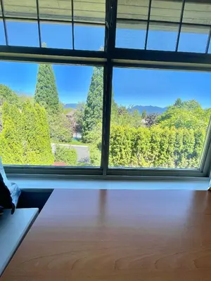 a room with a view of trees from a window at Cozy Guest Rooms Near UBC, Downtown and Beaches in Vancouver