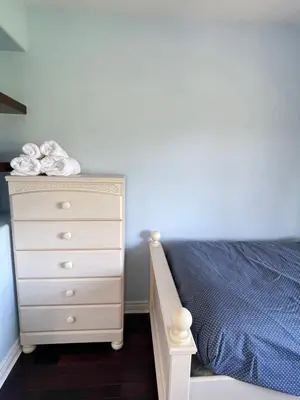 a bedroom with a bed and a dresser at Cozy Guest Rooms Near UBC, Downtown and Beaches in Vancouver